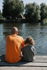 Fototapeta premium Man and child sitting and fishing on wooden dock by lake