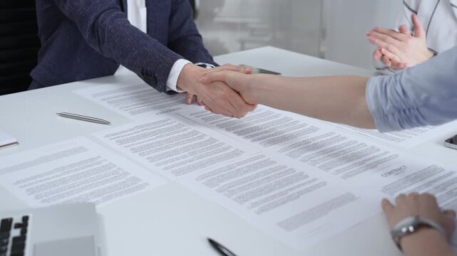 Business executives shaking hands, sealing an agreement after successful negotiations in a bright office, symbolizing partnership, collaboration, and a mutually beneficial deal signing