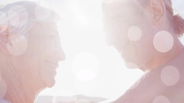Man and woman leaning closer as sun causing bokeh over faces, marketing shot showing intimacy