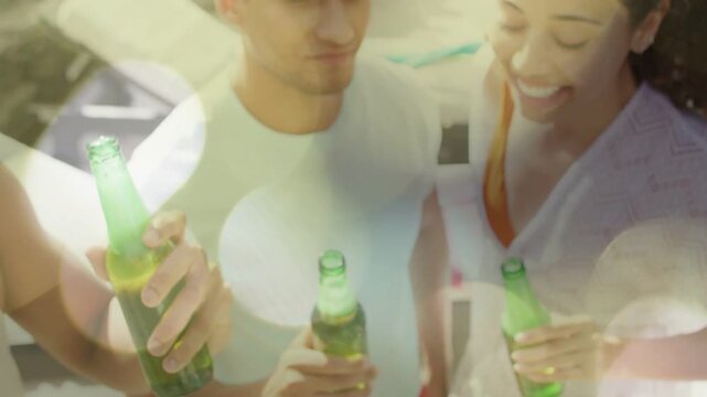 Lifestyle scene with friends lifting green bottles poolside while bokeh overlay clearing, toasting