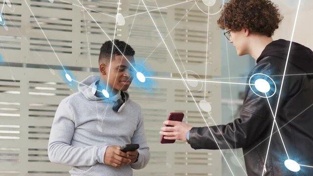 Hoodie man taking maroon phone from peer comparing screens while network overlay sharing tech data