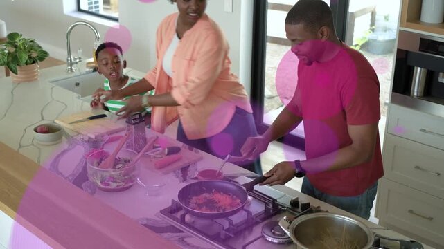 Mother dumping carrots into pan, dad stirring pot, family cooking, pink circles overlaying family