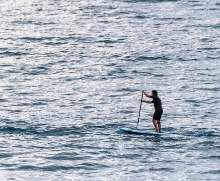 Stand-up paddler on the water at sunset