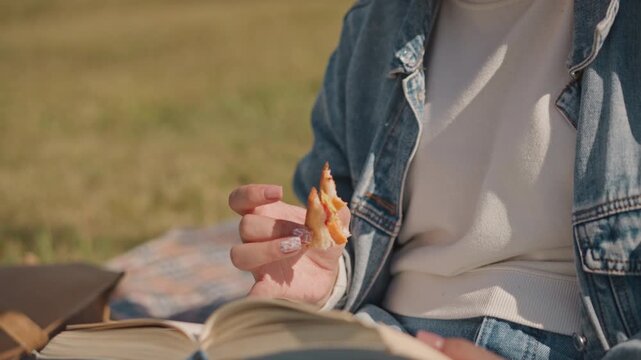 Caucasian writer holding flower while reading in meadow, open journal on lap with plaid blanket, gentle finger gestures on textured pages, nostalgic daydream mood, bohemian aesthetic during goldenhour