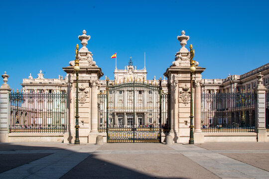 Royal Palace of Madrid main facade with ornate gate under clear blue sky