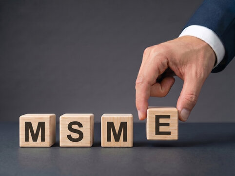business hand placing msme wooden blocks on dark desk representing micro small medium enterprise and business growth concept