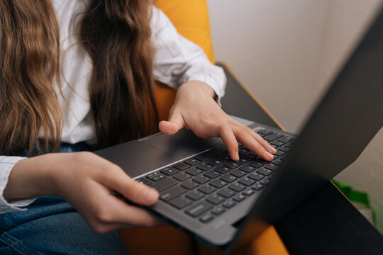 Closeup schoolgirl hands typing on laptop keyboard, engaging in remote work, online learning, digital communication, connecting with modern technology for productivity and education.
