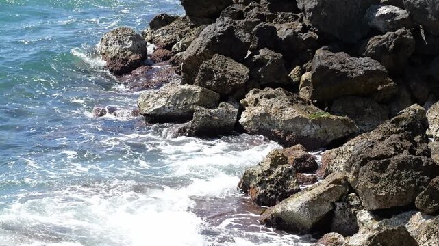 Surf washes over boulders on the coast of Cala Blava in Mallorca. Ideal for nature, travel, or relaxing background videos. 4K UHD (3840x2160), 25fps, 60 seconds, 905 MB.