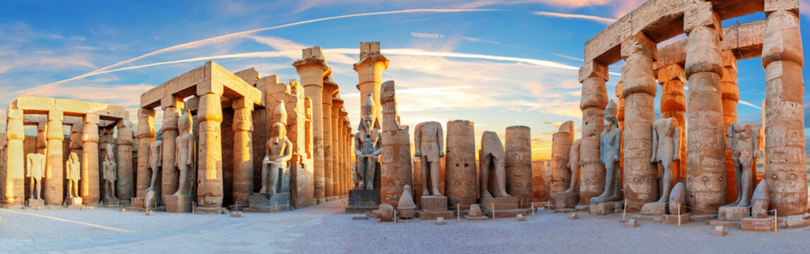 Panoramic view of Ramses II statues and columns in Luxor Temple at sunset, Egypt