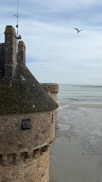 Exploring the historic walls of Normandy with views of the tide and the landscape