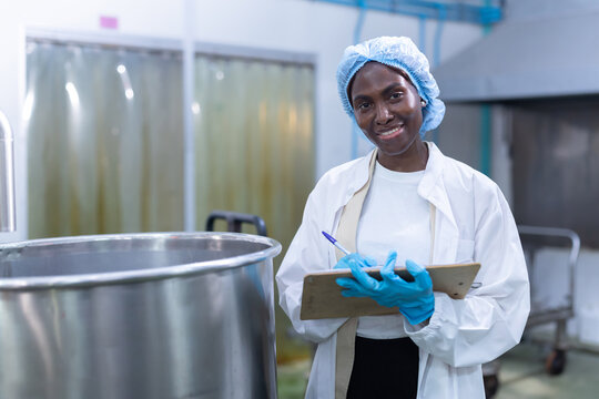 Black worker checksthe boiling process in food processing area