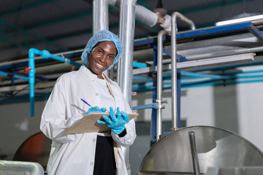 Black worker checksthe boiling process in food processing area