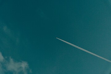 Fototapeta premium airplane with chemtrail in bright blue sky