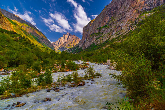 Majestic mountains and white water river in lush valley