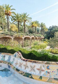 Colorful mosaic bench in Park Guell with palm trees