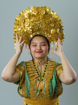 Young Woman Wearing Traditional Golden Southeast Asian Headdress and Ornate Costume, Portrait