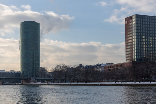 Moderne Hochh&auml;user und Wolkenkratzer an einem winterlichen Flussufer bei bew&ouml;lktem Himmel