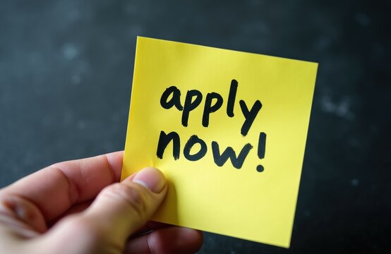 Hand holds yellow sticky note with black text apply now. Message conveys encouragement for job seeking or immediate action. Focus on opportunity and initiative.