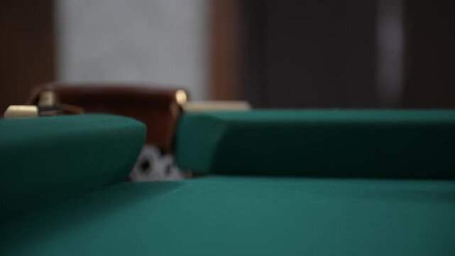 Rolling the ball with the lucky number 7 into the hole of the billiard table during the game