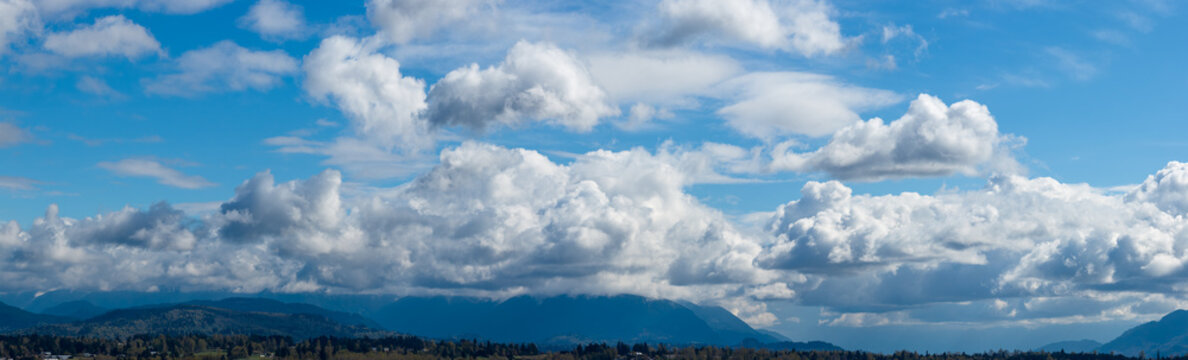 Dramatic Cloudscape Over Mountain Range and Blue Sky in British Columbia, Canada