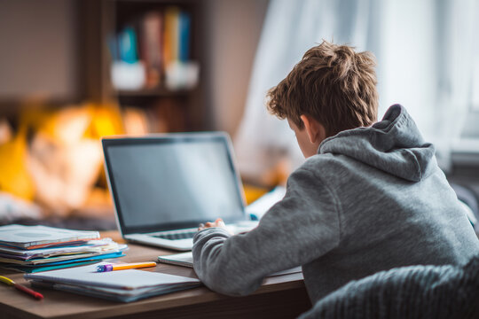 Young man studies or works on a laptop in a cozy home environment