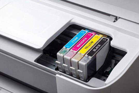 CMYK ink cartridges installed in a modern office printer for printing documents