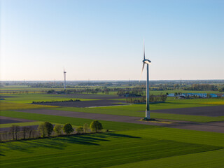 Fototapeta premium Wind Farm Fields: Renewable Energy Landscape in Vast Green Farmland