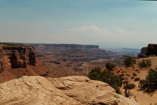 Expansive Sandstone With Distant Buttes. Majestic Desert Scene Featuring Layered Rocks And Wide Open Sky