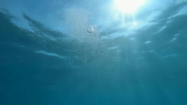水中から見上げる陽光と気泡が広がる透明感あふれる幻想的な夏の水中風景