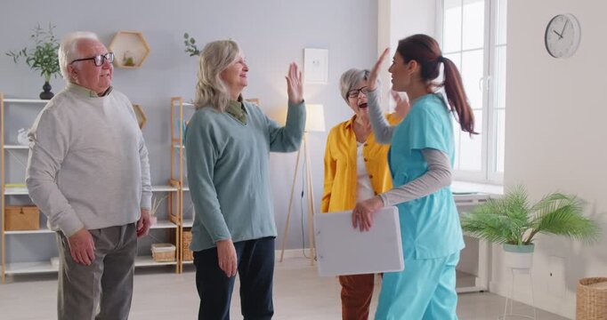 Friendly team competition, happy elderly with nurse, caregiver, carer or support worker, active seniors in social recreational friendship club in retirement house, retired community, older adults fun