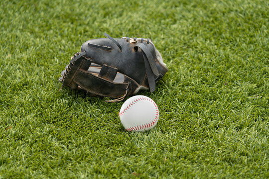 Kid's baseball glove and ball on grass