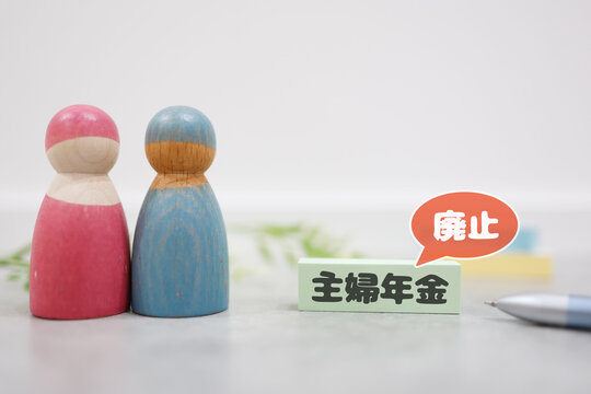 夫婦年金廃止。木製人形と付箋で表現した主婦年金制度終了のイメージ