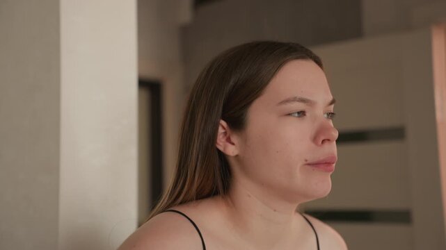 Pregnant caucasian woman doorway practicing breathwork soft morning light, wearing black cami with visible bump, focused pursed lips, controlled inhale and exhale, preparing mentally for labor, calm