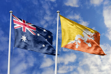 Australia and Bhutan flags waving in a clear blue sky symbolizing a powerful diplomacy a strategic partnership, and a shared vision of unity for a sustainable future. © fatih