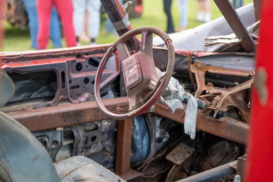 Selective focus on the interior steering column and wheel on a modified car for a demolition derby