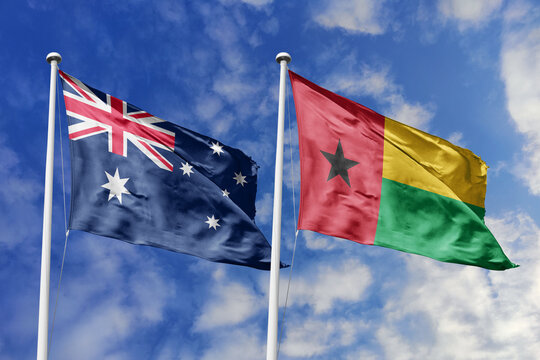 Australia and Guinea-Bissau flags waving in a clear blue sky symbolizing a powerful diplomacy a strategic partnership, and a shared vision of unity for a sustainable future.