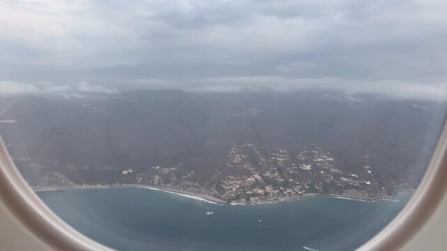 Airplane window view of La Guaira coastline before landing