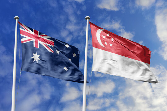 Australia and Singapore flags waving in a clear blue sky symbolizing a powerful diplomacy a strategic partnership, and a shared vision of unity for a sustainable future.