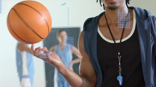 Camera pulling back while sports coach spinning ball on finger showing team skill with blue overlay