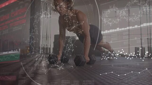 Woman doing gym set on mat, pushing onto dumbbells activating data, alternating rows for core power
