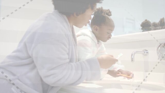 Mother guiding daughter at bathroom sink, turning faucet and rinsing toothbrush for oral health