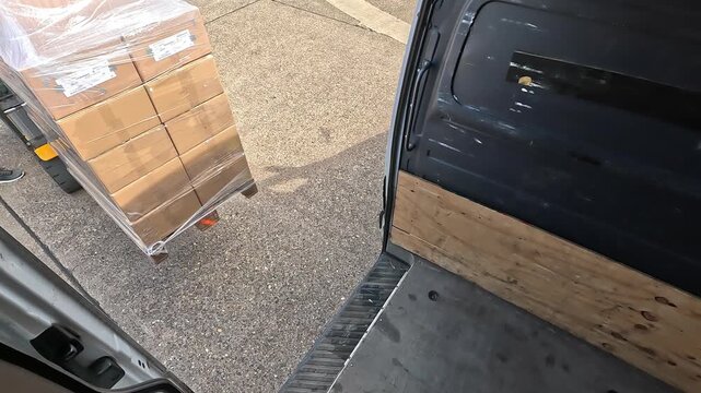 Forklift carrying pallet cargo driving away from a delivery van after unloading. Warehouse logistics, transportation and supply chain operations concept.