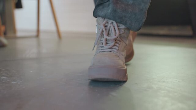 Shoes move intentionally. Footwear approach counter confidently. Journeys in shoes lead to counter with purpose. Stylish boots step purposefully across tiled cafe floor towards service area