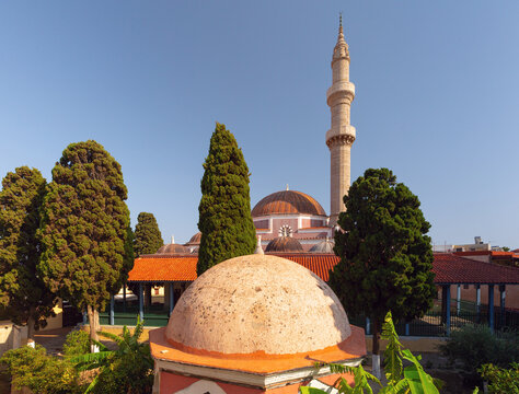 Mosque with minaret and domes among trees in old town of Rhodes Greece