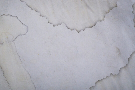 Abstract background of old vintage paper with water stains, grungy weathered paper texture for antique design or scrapbooking.
