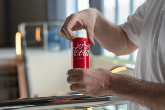 Opening a Coca Cola can with original taste in hand on a balcony. Russia, Irkutsk, April 26, 2026