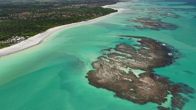 Drone view of the reefs during low tide at Ipioca Beach, Macei&oacute;, reveals natural patterns in the sea and shallow crystal-clear waters - Alagoas, Brazil