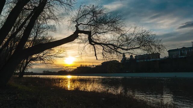 sunset over the embankment on the Ural River in Orenburg, time-lapse - the sun sets behind the horizon