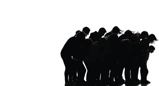Silhouette of a large diverse group of people standing together in a tight huddled formation