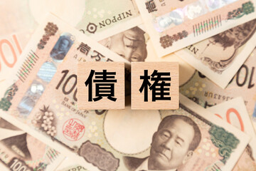 Fototapeta premium 「債権」と書かれたブロックとたくさんの一万円札